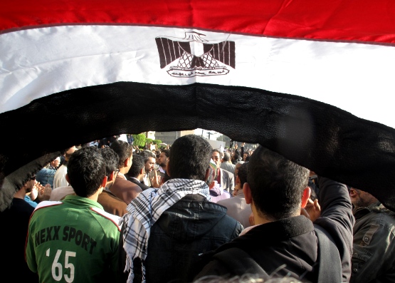 •La bandiera egiziana sventolata di fronte alla polizia